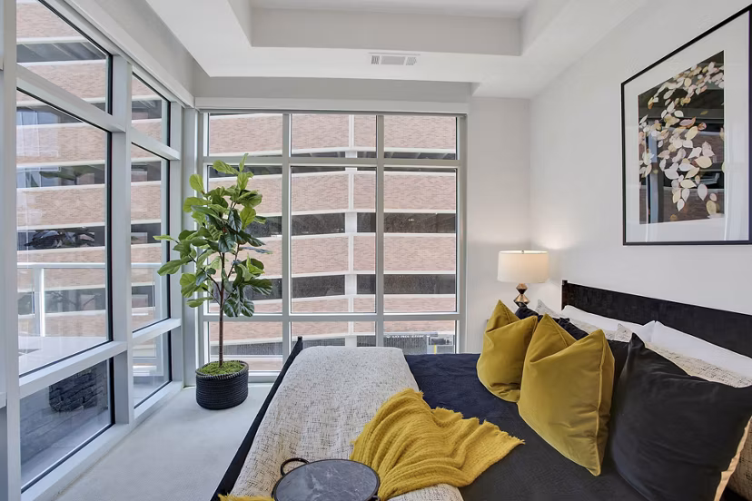 Modern bedroom with elegant furnishings at Overture 9th + CO Apartments, a luxury Greystar property located in a premium urban setting