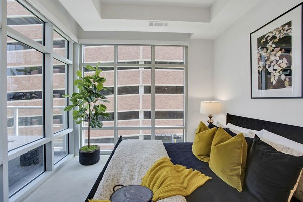 Modern bedroom with elegant furnishings at Overture 9th + CO Apartments, a luxury Greystar property located in a premium urban setting