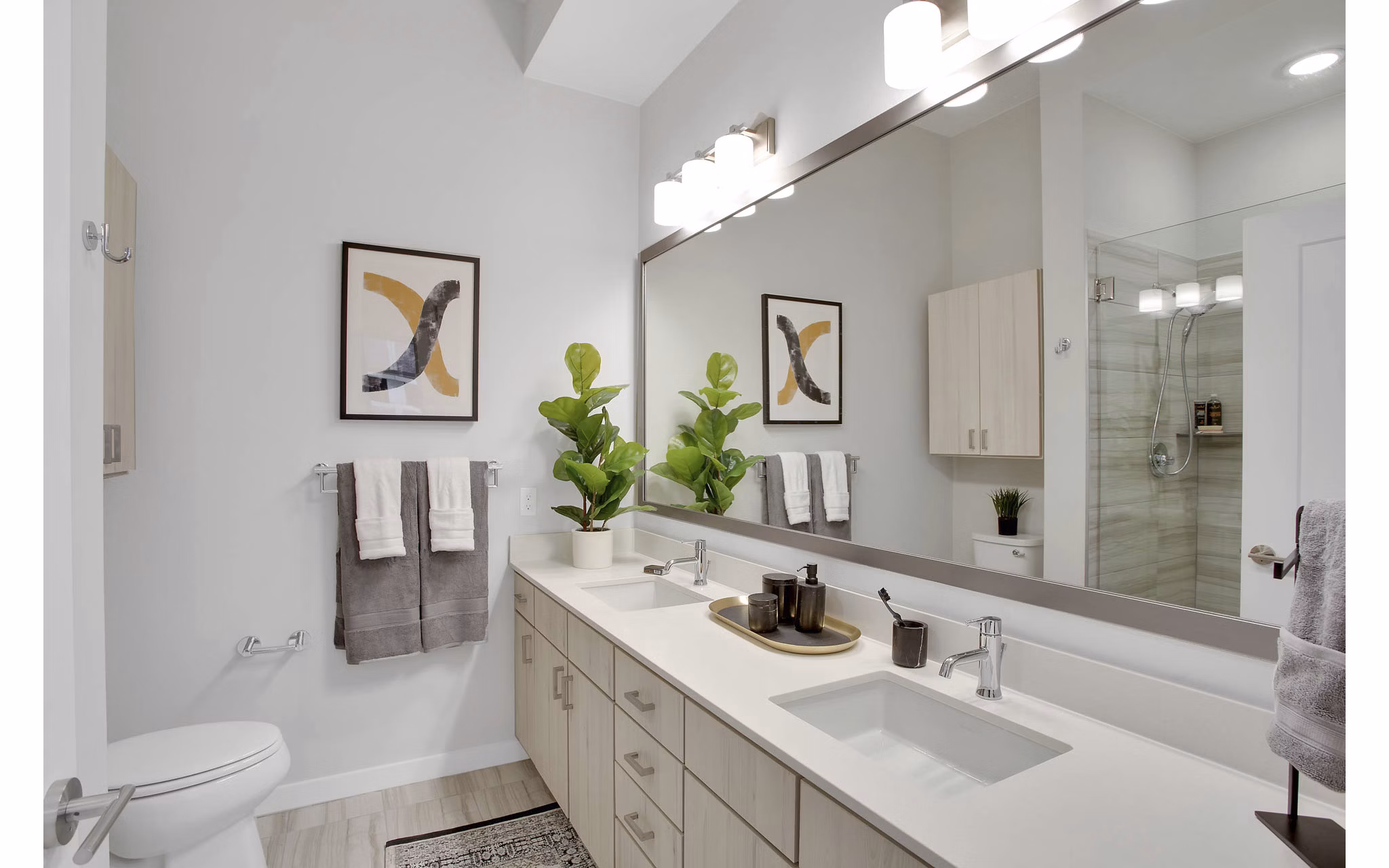Modern bathroom with sleek fixtures and ample lighting at Overture 9th + CO Apartments