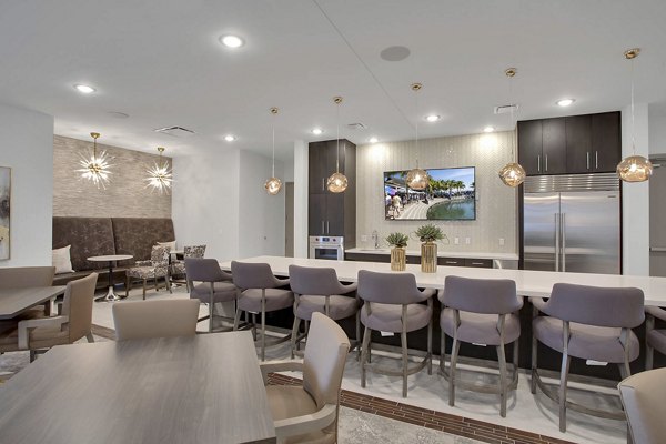 Clubhouse interior featuring modern furnishings and community workspace at Overture 9th + CO Apartments