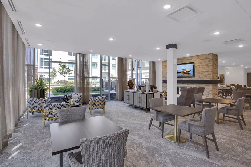 Modern clubhouse with cozy seating and fireplace at Overture 9th + CO Apartments