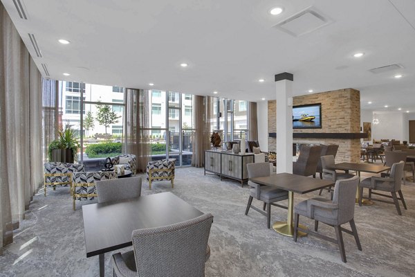 Modern clubhouse with cozy seating and fireplace at Overture 9th + CO Apartments