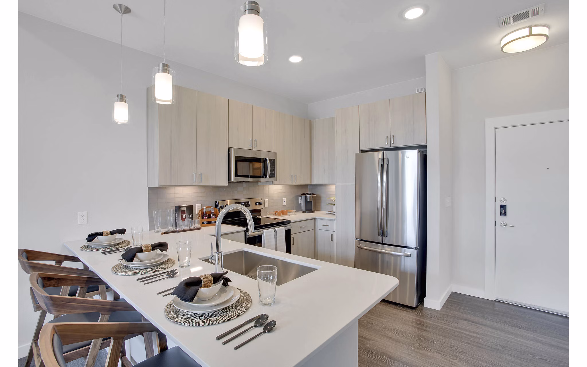 Modern kitchen with sleek countertops and stainless steel appliances at Overture 9th + CO Apartments in Denver