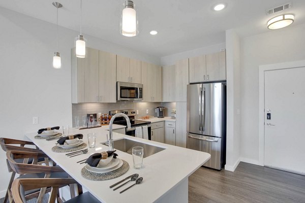 Modern kitchen with sleek countertops and stainless steel appliances at Overture 9th + CO Apartments in Denver
