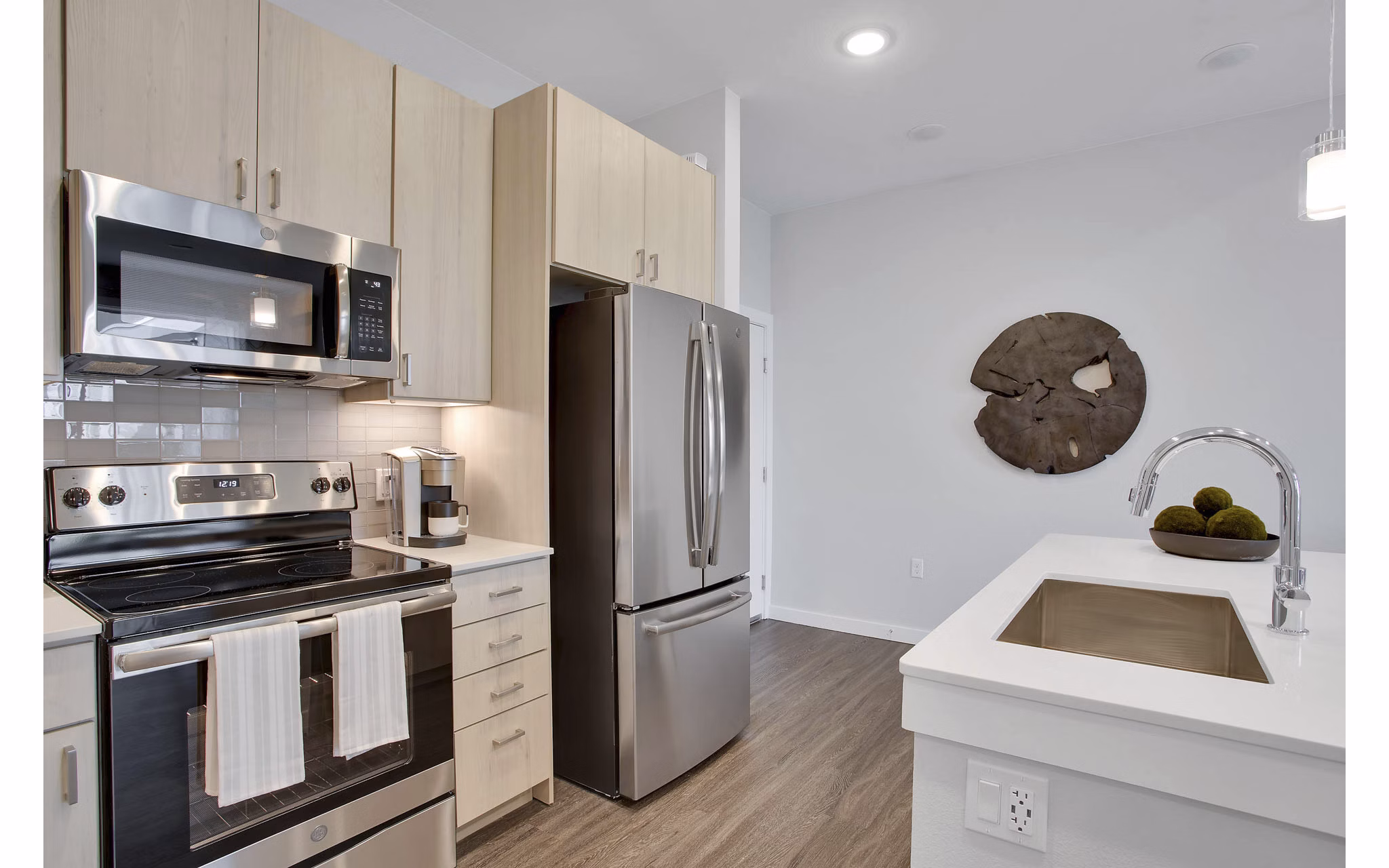 Modern kitchen with granite countertops and stainless steel appliances at Overture 9th + CO Apartments