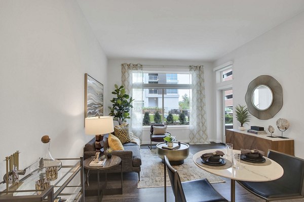 Modern living room with sleek furniture and large windows at Overture 9th + CO Apartments