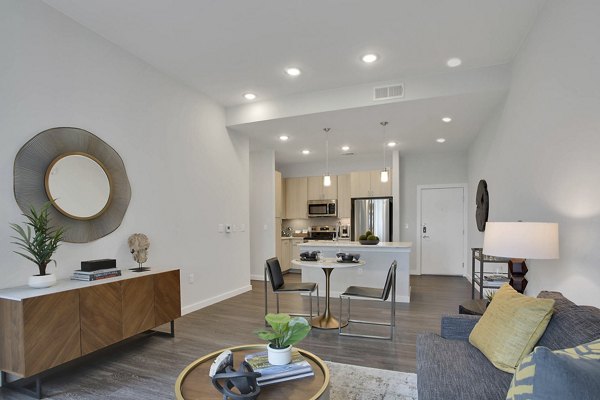 Modern living room with sleek furnishings and ample natural light at Overture 9th + CO Apartments