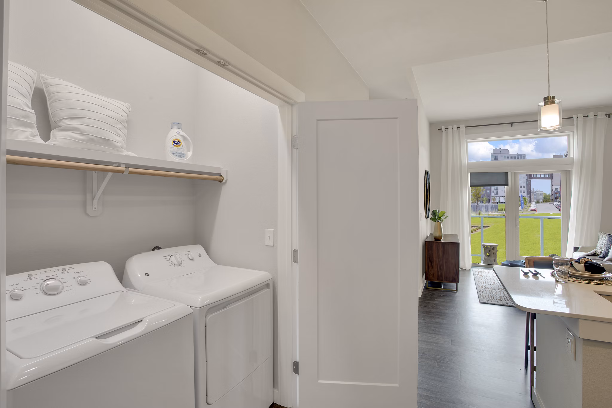 Laundry room with modern appliances at Overture 9th + CO Apartments, a luxury living community by Greystar