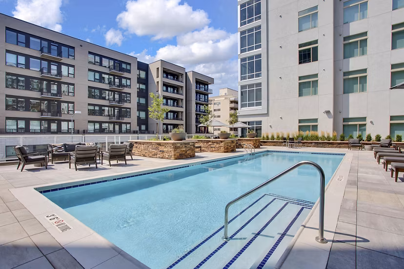Stylish pool area with sun loungers and lush landscaping at Overture 9th + CO Apartments