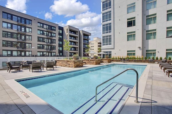 Stylish pool area with sun loungers and lush landscaping at Overture 9th + CO Apartments