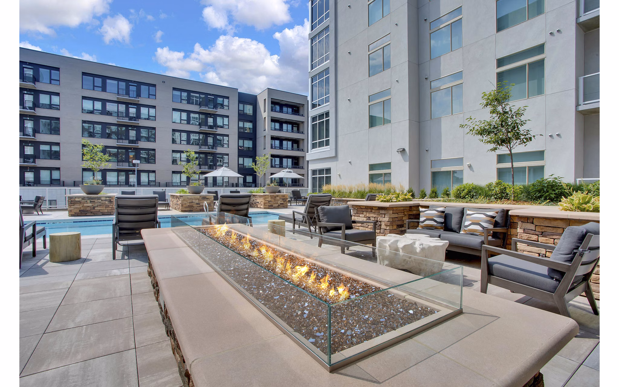 Cozy outdoor fire pit at Overture 9th + CO Apartments, perfect for relaxing evenings and social gatherings in a luxurious setting
