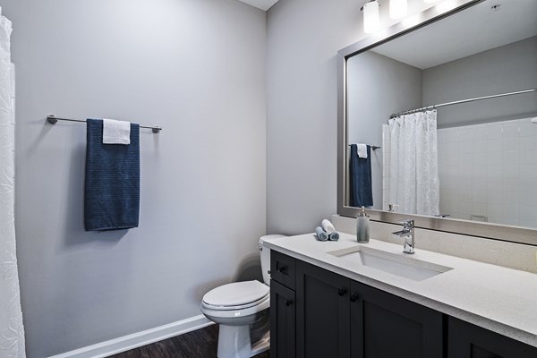 Luxurious bathroom with marble countertops and glass shower at Avana on Main Apartments