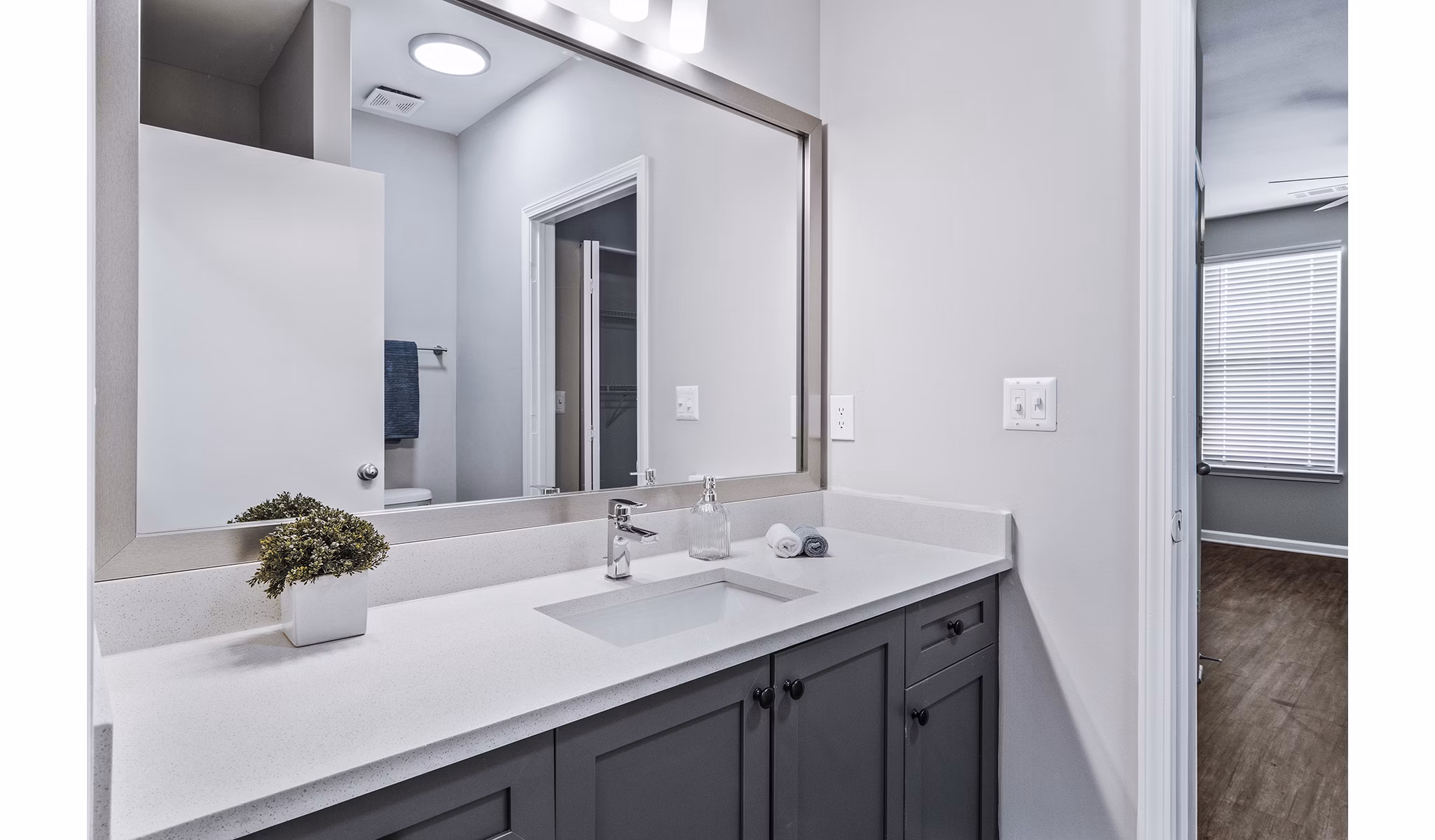 Bathroom with sleek fixtures and marble countertops at Avana on Main Apartments