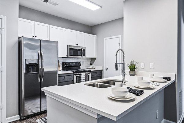 Modern kitchen with stainless steel appliances at Avana on Main Apartments