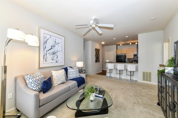 Bright living room with modern furnishings and large windows in Avana on Main Apartments