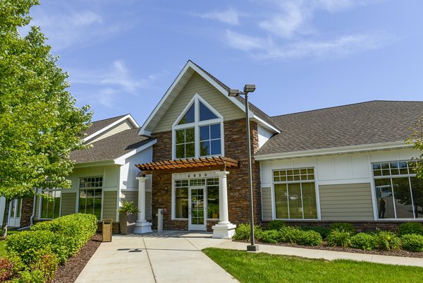 Modern luxury apartments with a peaked roof and large windows in a landscaped setting