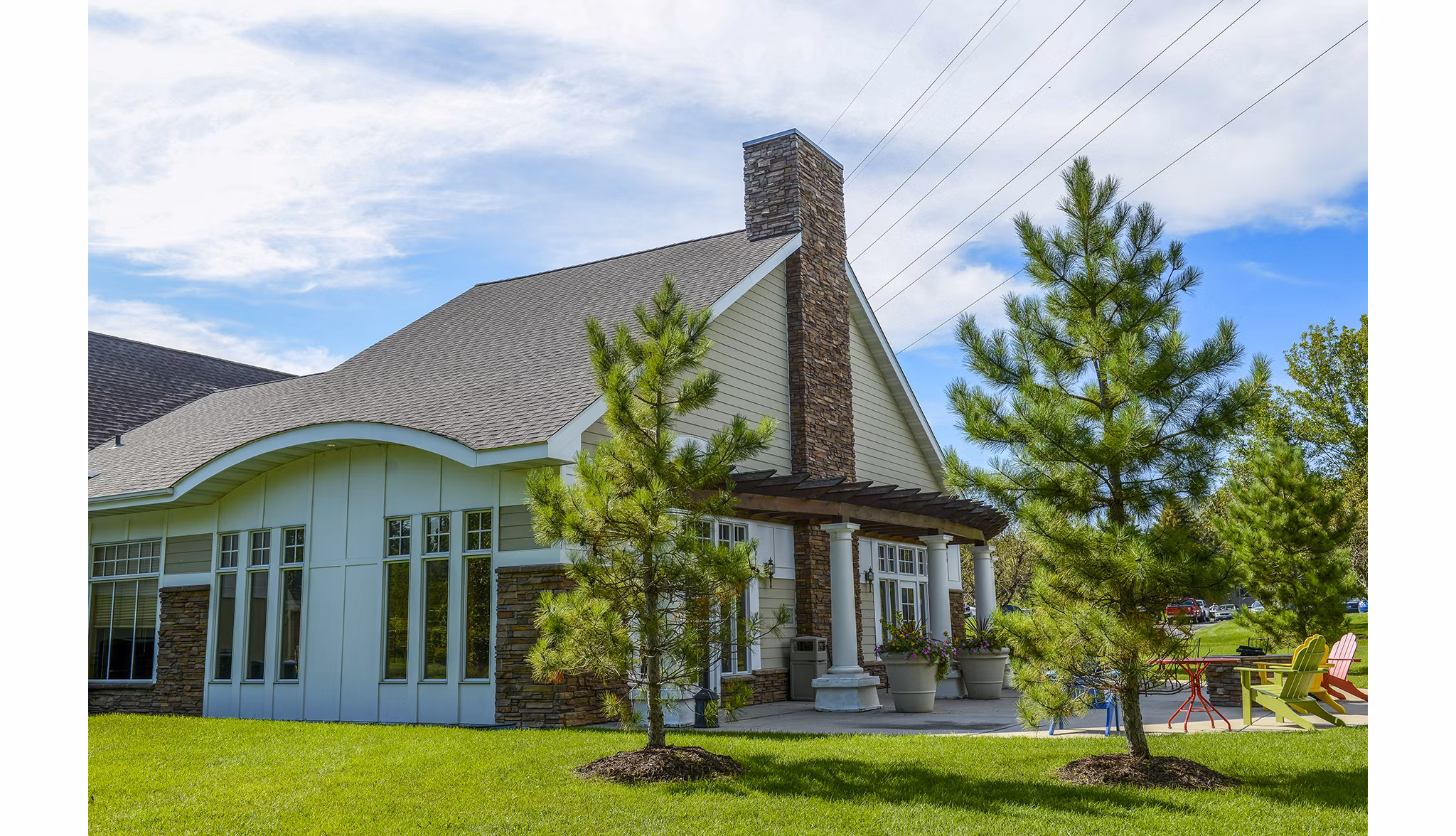 Luxury apartments with sloped roof, patio seating, and landscaped surroundings