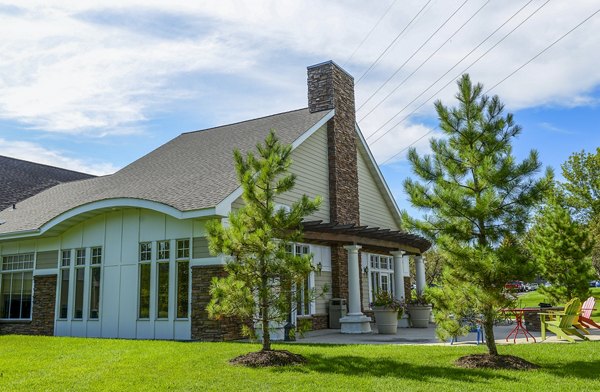 Luxury apartments with sloped roof, patio seating, and landscaped surroundings