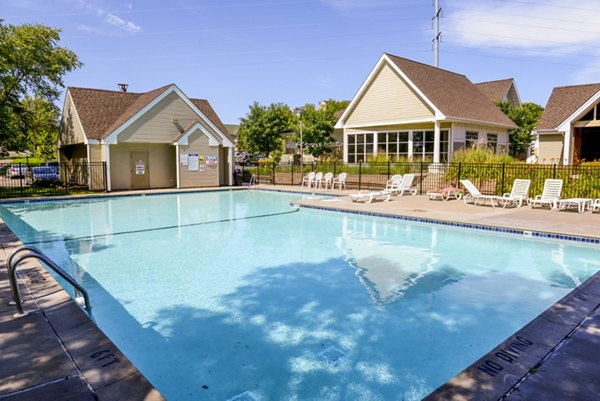 Stunning outdoor swimming pool with lounge chairs surrounded by luxury apartments