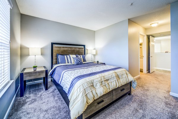 Cozy bedroom with modern furnishings at Autumn Woods Apartments, a Greystar luxury residence