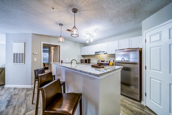 Modern kitchen featuring granite countertops and stainless steel appliances in Autumn Woods Apartments