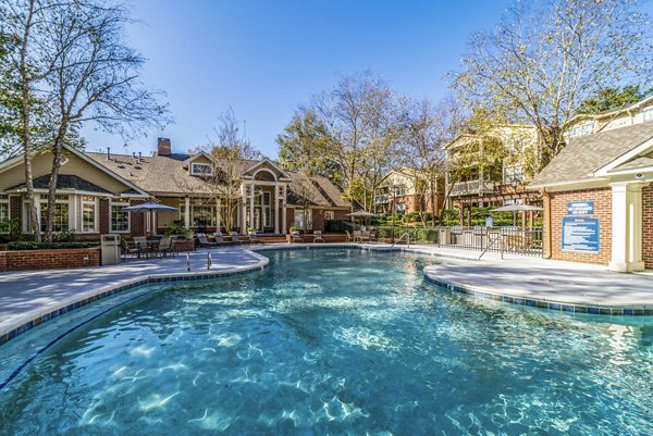 Sunny poolside retreat at Autumn Woods Apartments, offering a relaxing oasis with sparkling water and surrounding greenery