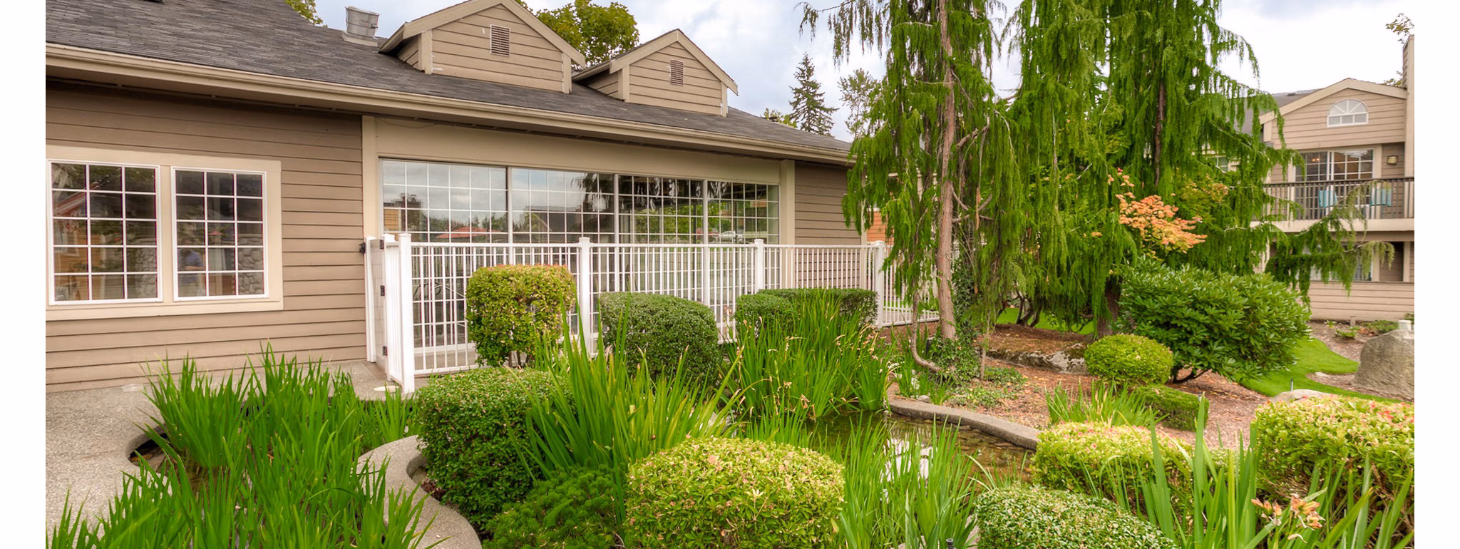 Riverstone Apartments: Elegant view of luxury apartments with lush landscaping in the vibrant community of Riverstone