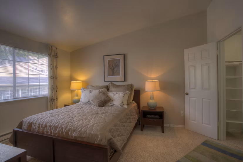 Spacious bedroom with contemporary design and large windows in Riverstone Apartments