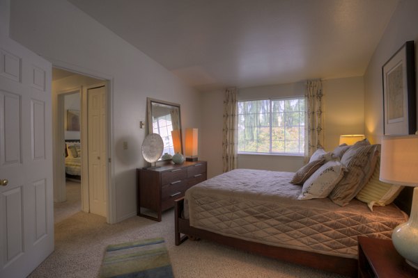 Bedroom featuring elegant decor and ample natural light at Riverstone Apartments