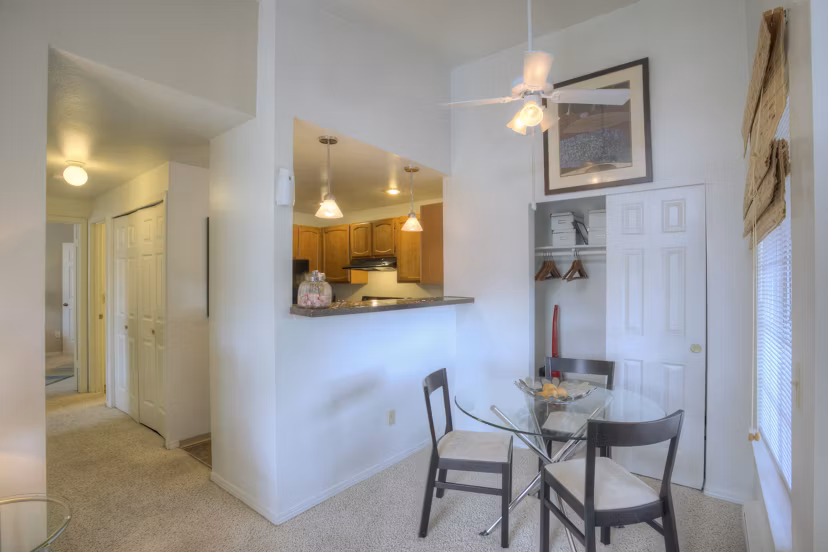 Dining room featuring elegant furnishings and large windows at Riverstone Apartments