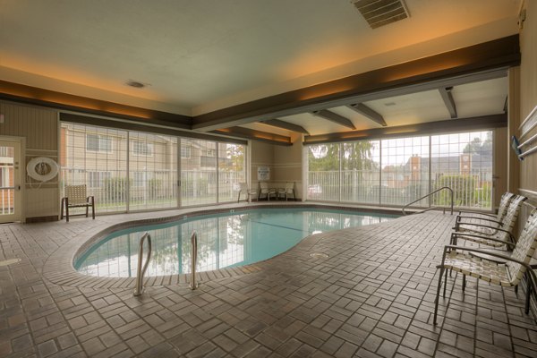 Elegant outdoor pool surrounded by lush greenery at Riverstone Apartments