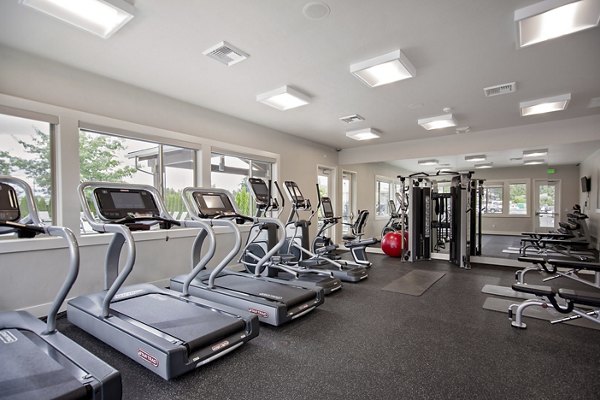 State-of-the-art fitness center featuring cardio machines and free weights at Trio Pointe luxury apartments