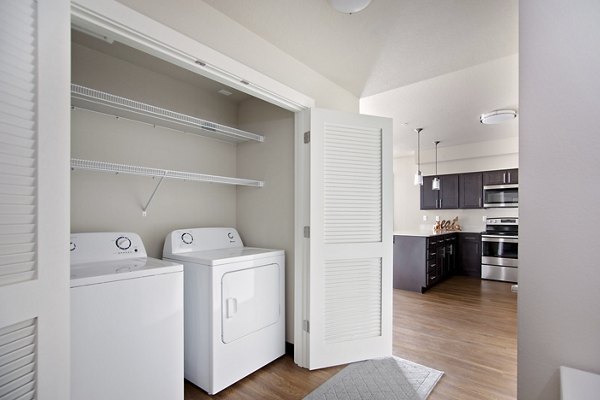 Laundry room featuring modern appliances at Trio Pointe apartments