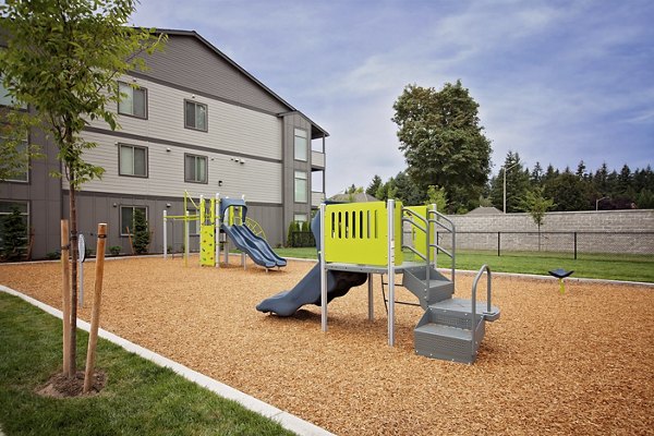 Modern playground with colorful equipment at Trio Pointe apartments, ideal for families seeking luxury living