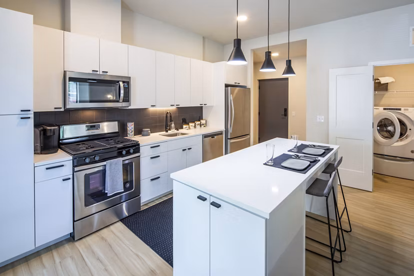 Modern kitchen with stainless steel appliances and granite countertops at Irvine Exchange Apartments