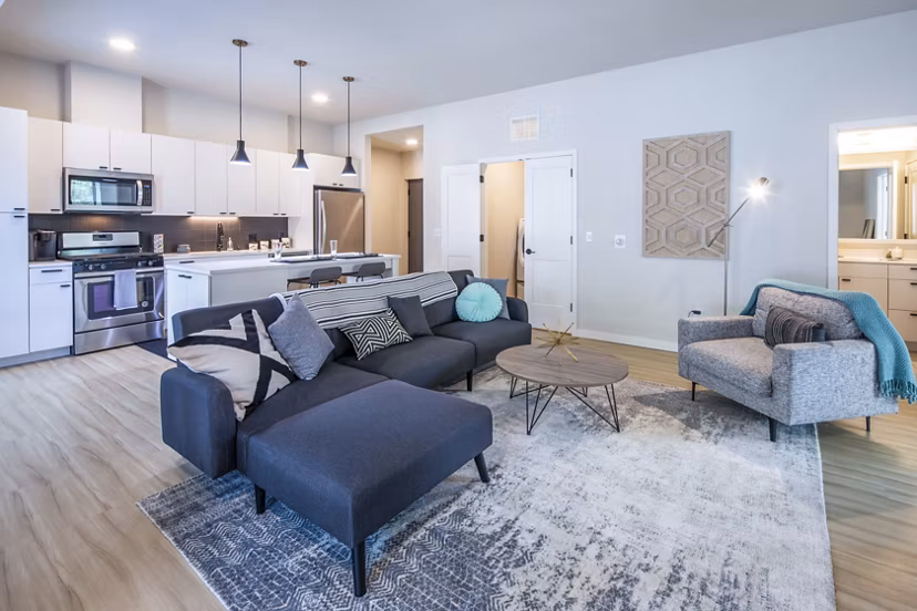 Spacious living room with modern furnishings in Irvine Exchange Apartments, featuring natural light and open design