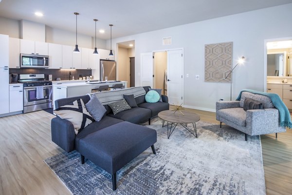 Spacious living room with modern furnishings in Irvine Exchange Apartments, featuring natural light and open design