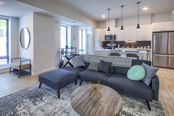 Modern living room with cozy seating and large windows at Irvine Exchange Apartments