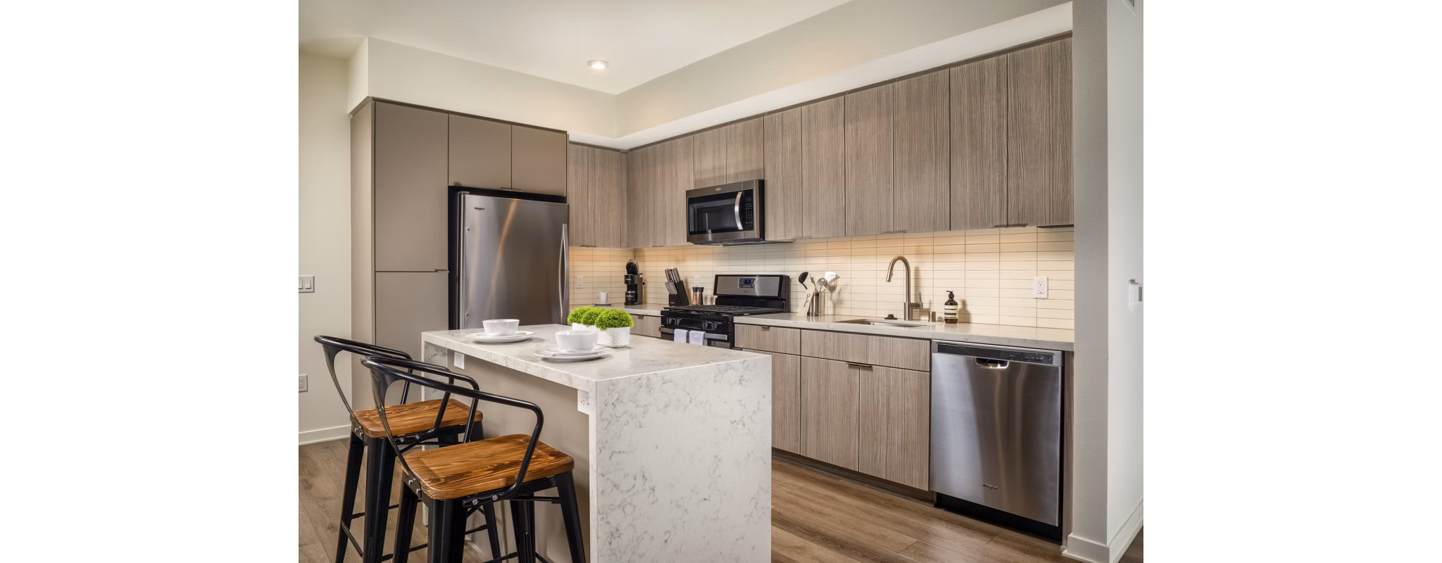 Kitchen with modern appliances and sleek cabinetry at One Paseo Living Apartments