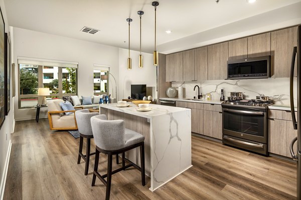 Modern kitchen featuring sleek countertops and stainless steel appliances at One Paseo Living Apartments