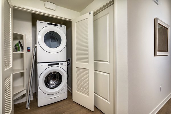 Modern laundry room equipped with high-efficiency washers and dryers at One Paseo Living Apartments