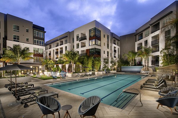 One Paseo Living Apartments: Serene outdoor pool with lounge chairs in a luxury community setting
