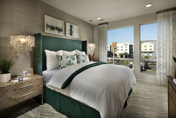 Cozy bedroom with modern decor and large windows at Anden luxury apartments
