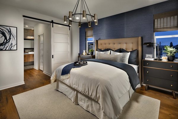 Cozy bedroom with elegant design at Anden luxury apartments, showcasing a serene space with modern furnishings and ambient lighting