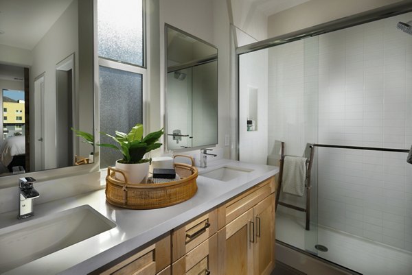 Modern bathroom with sleek countertops and large mirror in Anden luxury apartments