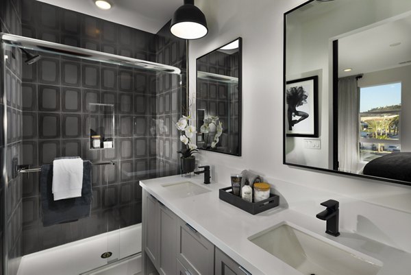 Modern bathroom with marble countertops and glass shower in Anden luxury apartments