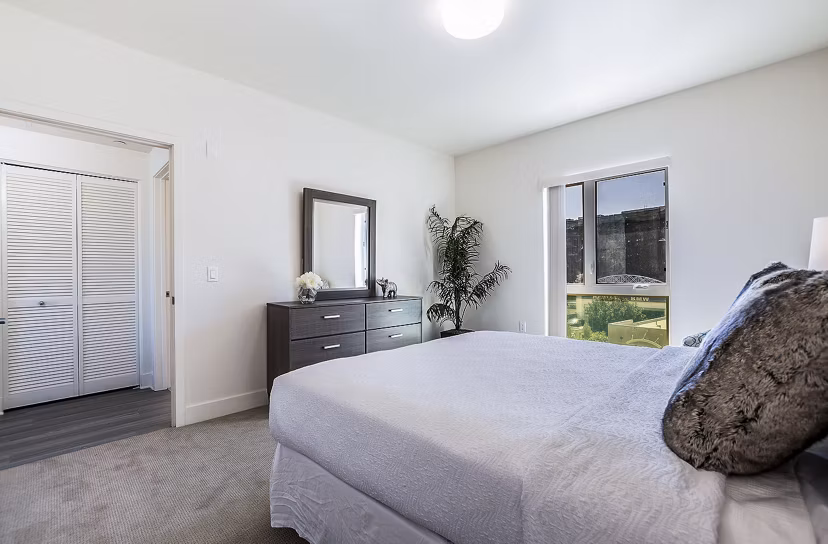 Cozy bedroom with modern furnishings at CC Tan Center Apartments, luxury living by Greystar