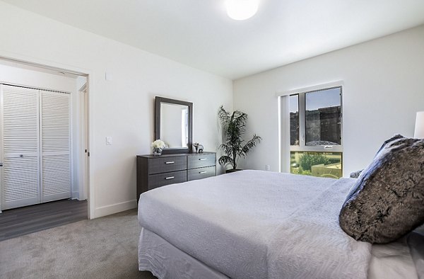 Cozy bedroom with modern furnishings at CC Tan Center Apartments, luxury living by Greystar