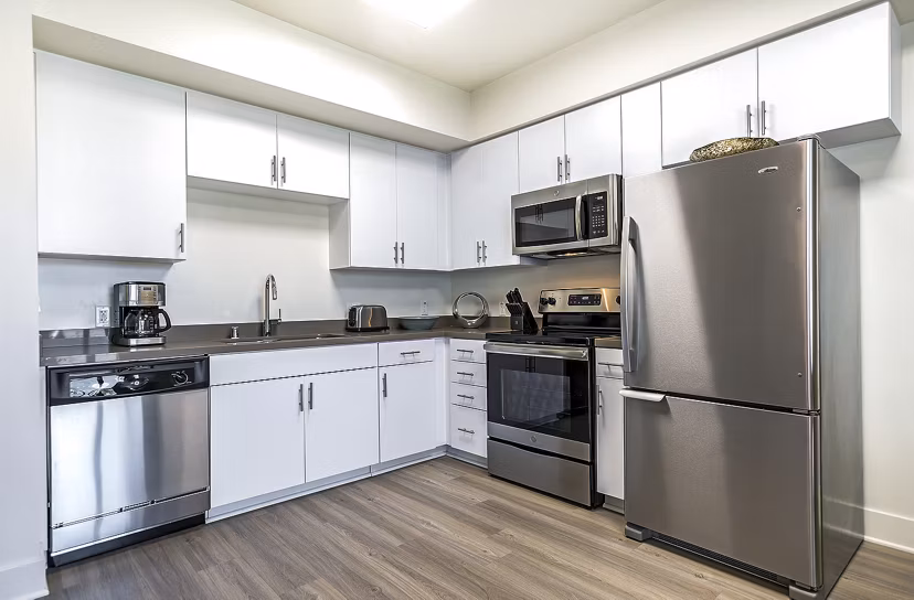 Modern kitchen with stainless steel appliances and granite countertops at CC Tan Center Apartments