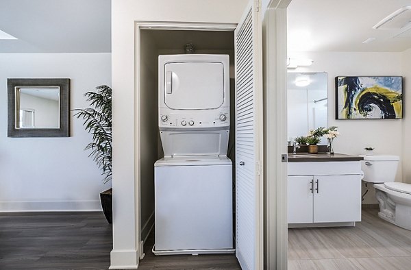 Laundry room with modern appliances at CC Tan Center Apartments